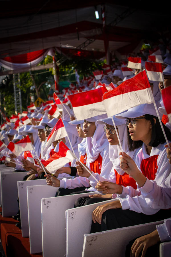 Pelajar Indonesia mengibarkan bendera merah putih kecil saat upacara